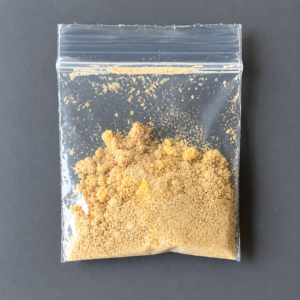 Yellow crystalline extract powder inside a sealed transparent inner sachet bag