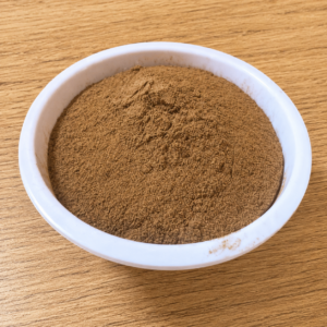Fine brown shredded botanical powder inside a clear glass storage jar